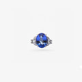 Peter Marco blue sapphire ring with diamond side stones and diamond detailing on a white metal band