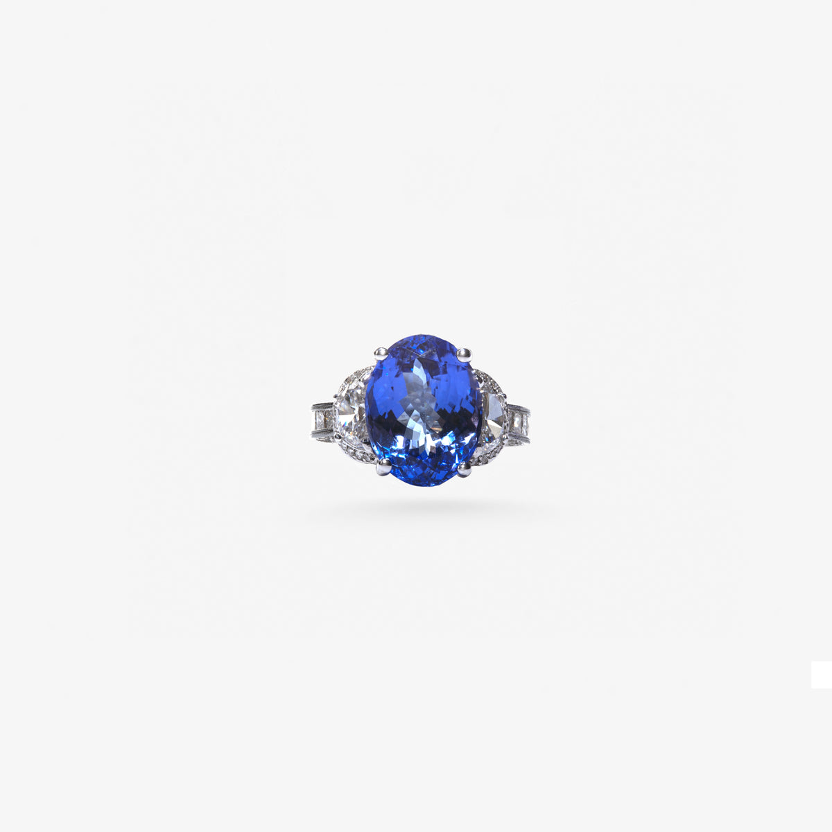 Peter Marco blue sapphire ring with diamond side stones and diamond detailing on a white metal band
