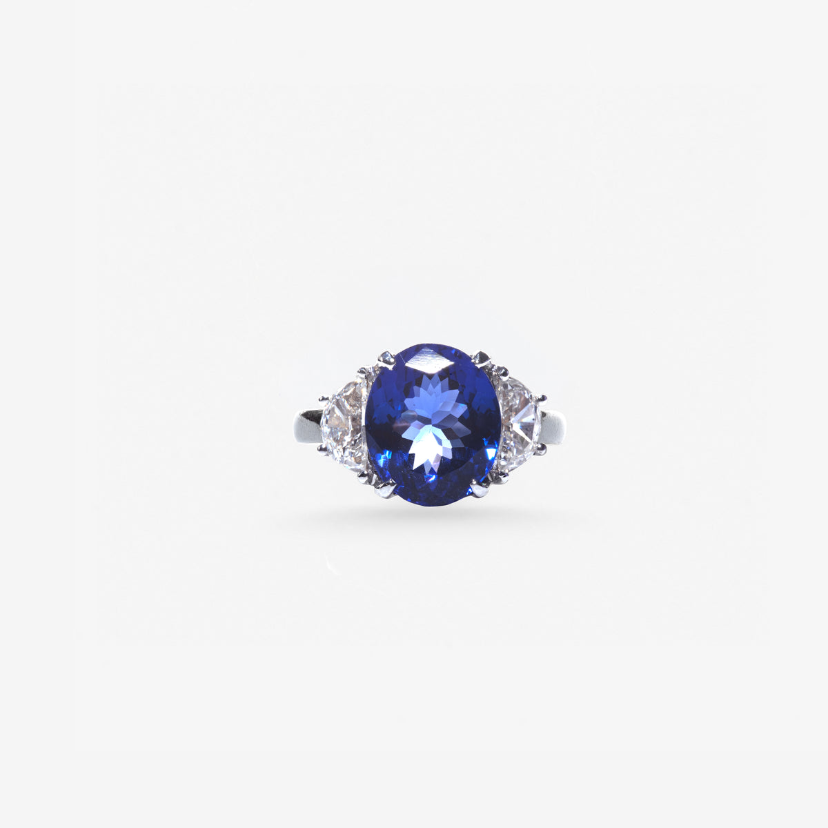 Peter Marco blue sapphire ring featuring an oval blue center gemstone with diamond accents on either side.