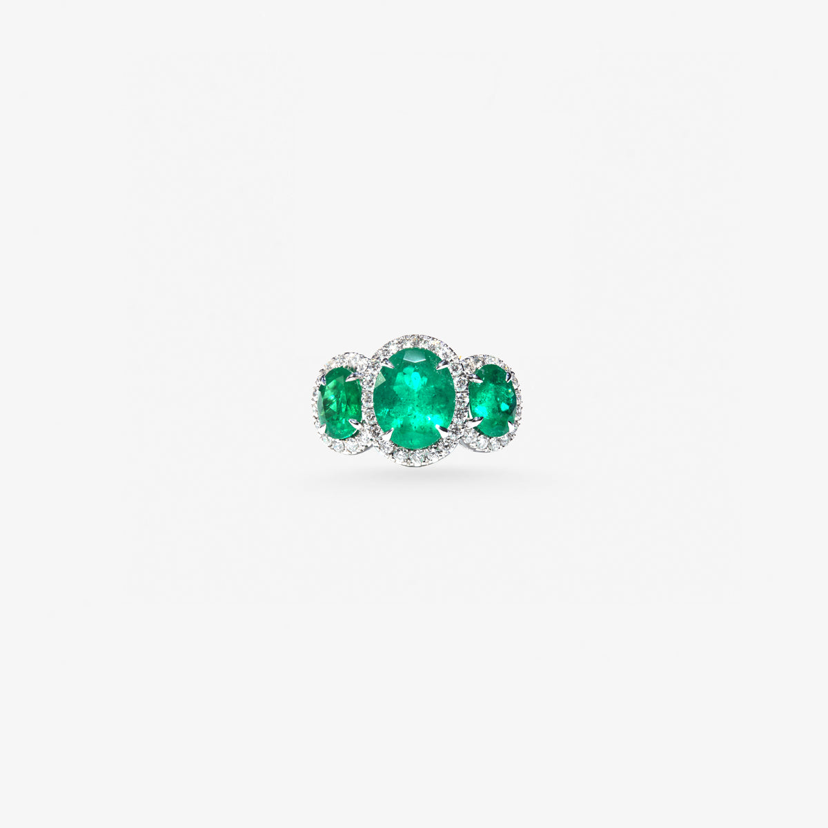 Peter Marco emerald ring featuring three green gemstones surrounded by diamond accents in a white metal setting.