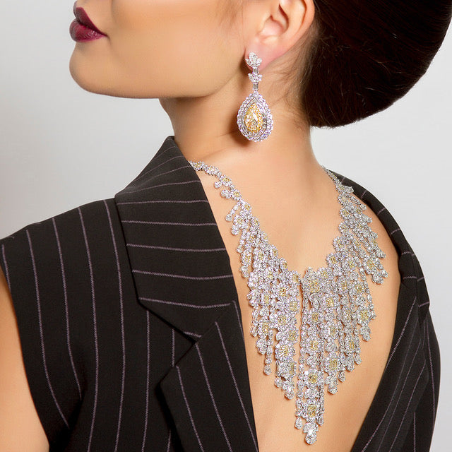 peter marco girl wearing a white diamond and yellow diamond bracelet and earrings