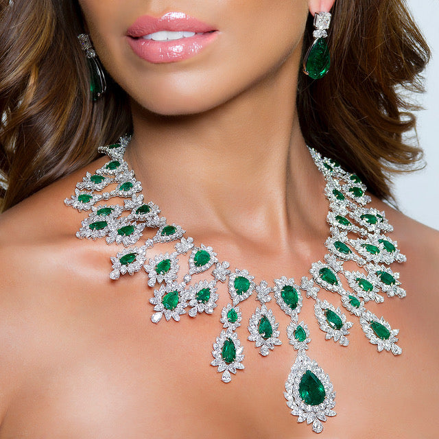 peter marco model wearing a emerald and white diamond earrings and necklace