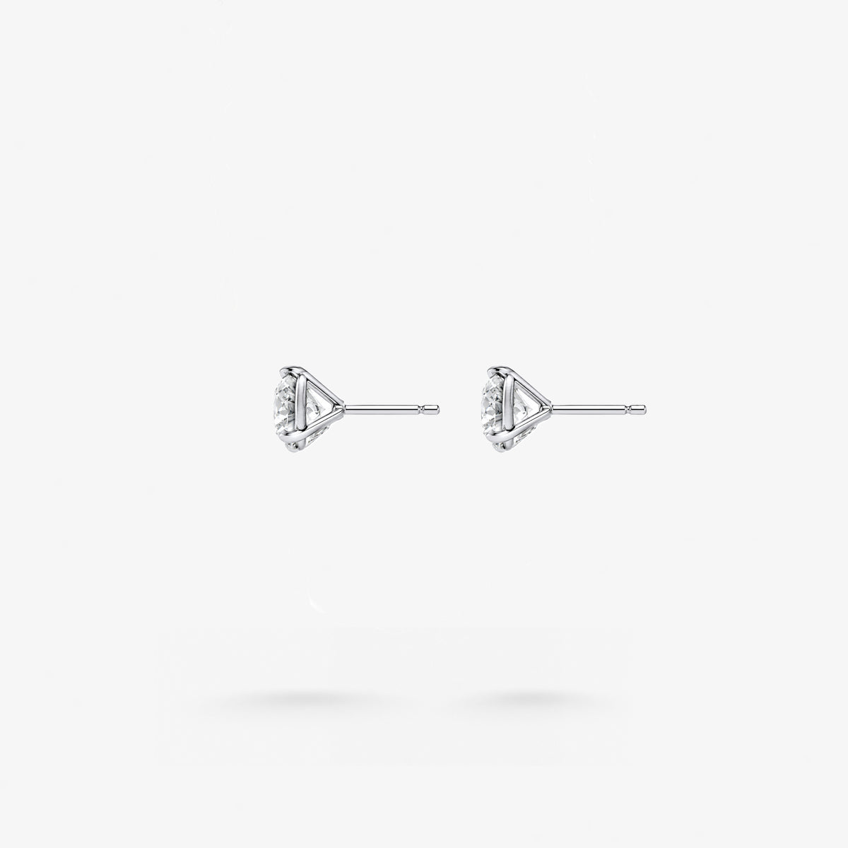 Peter Marco three-prong round cut white diamond stud earrings, side view
